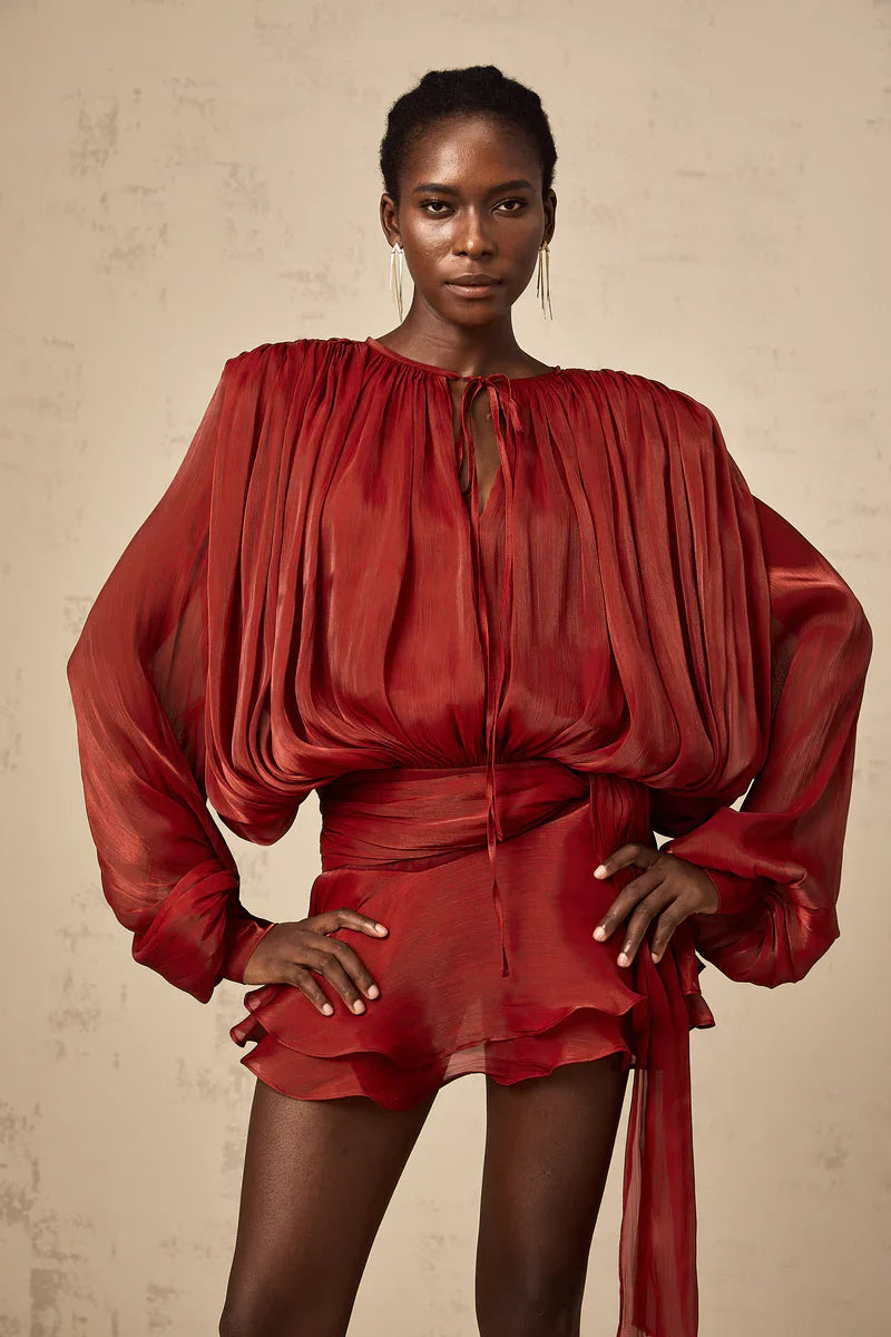 Model wearing red Luxe Flowy Mini Dress by Isadora London – bold and elegant.