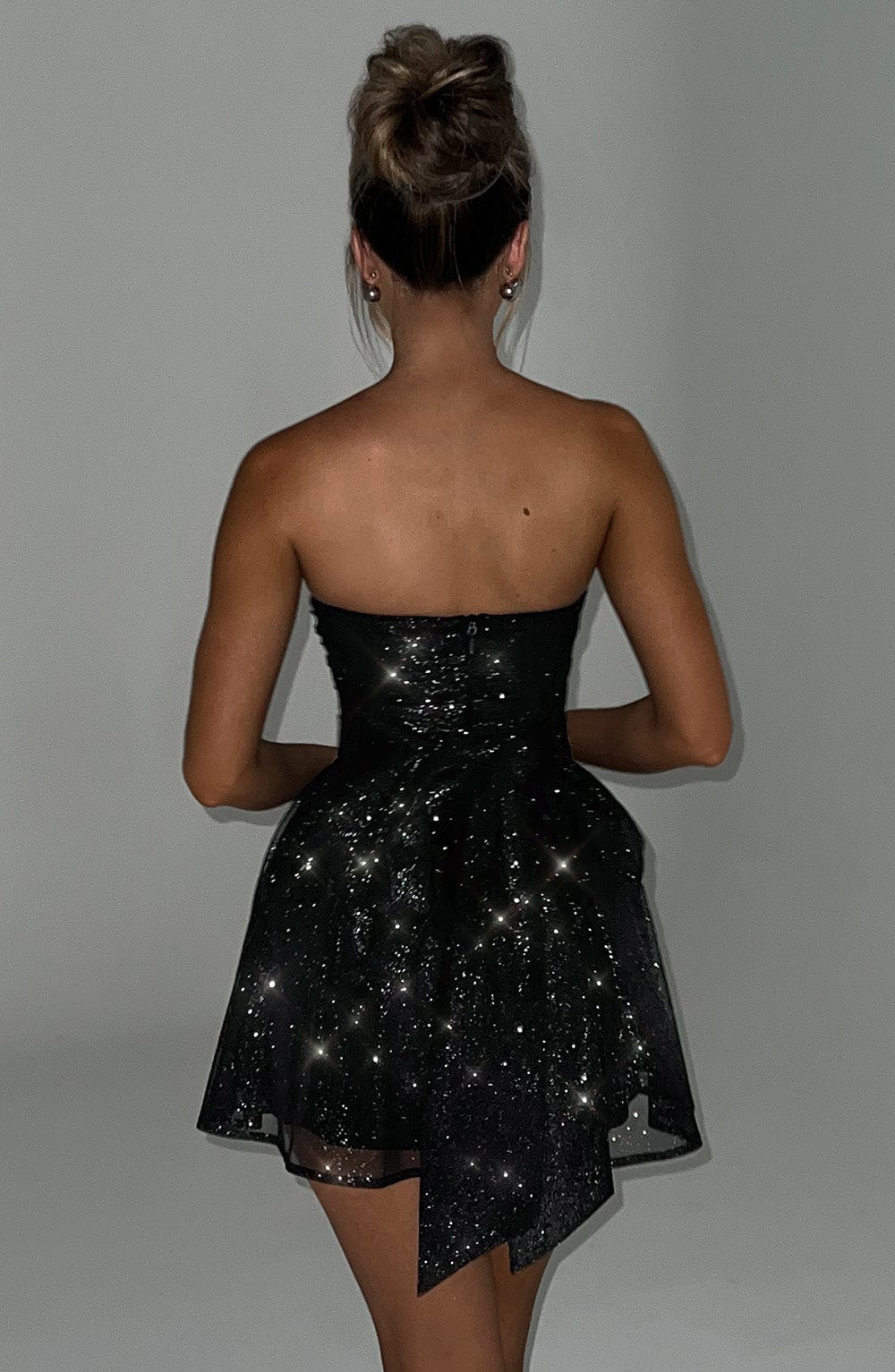 Strapless black sequin mini dress with oversized bow detail – back view