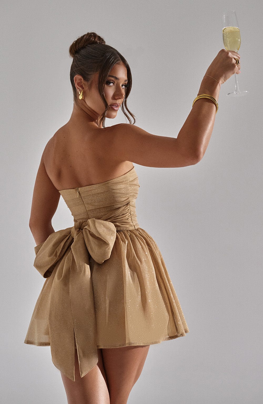 Golden strapless mini dress with waist-cinching fit and flared hemline