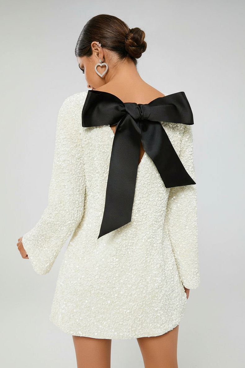 Ivory glitter mini dress back view – statement black bow and low scoop back – Isadora London.
