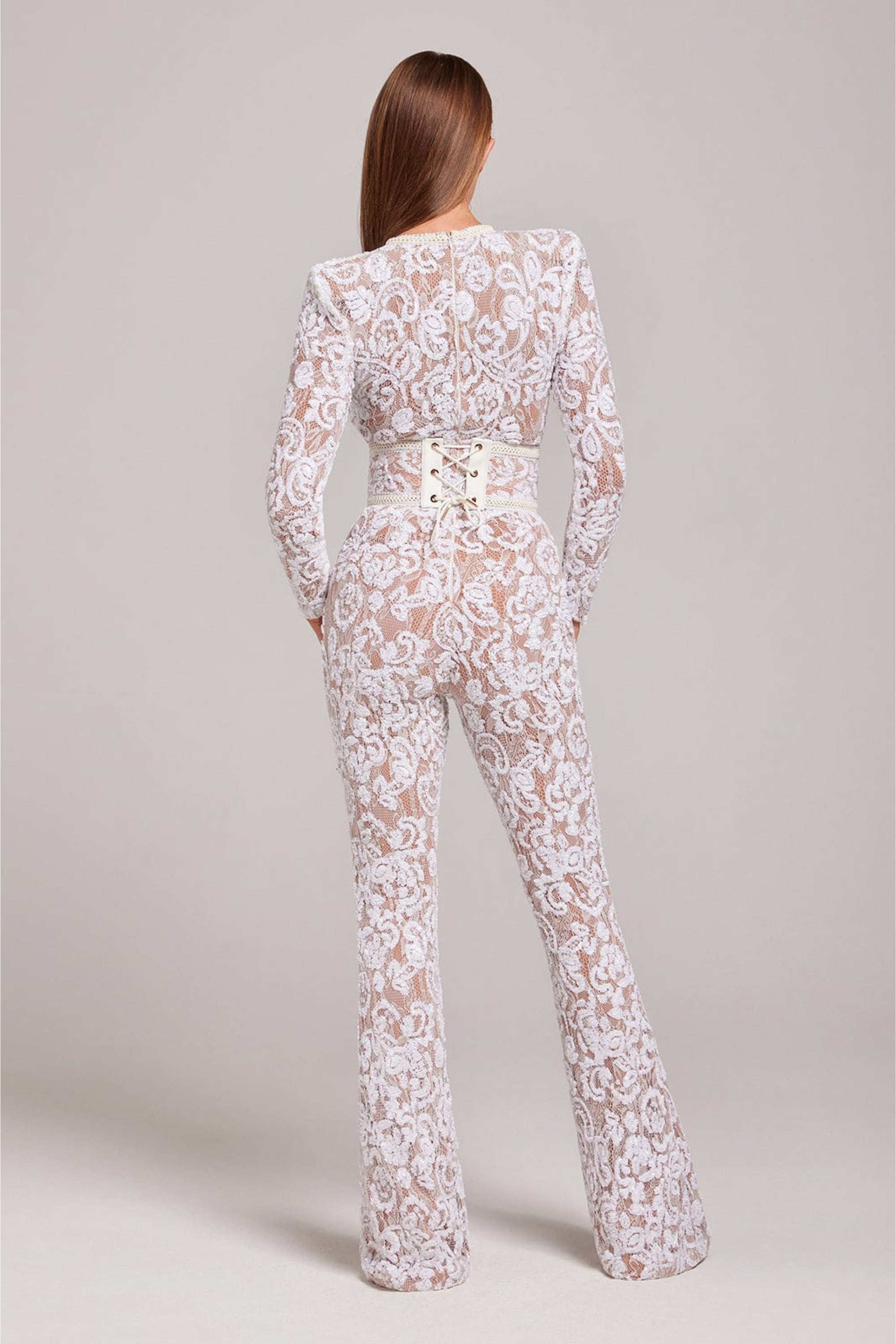 Back view of the white lace jumpsuit showing the fitted silhouette and sheer floral lace details.