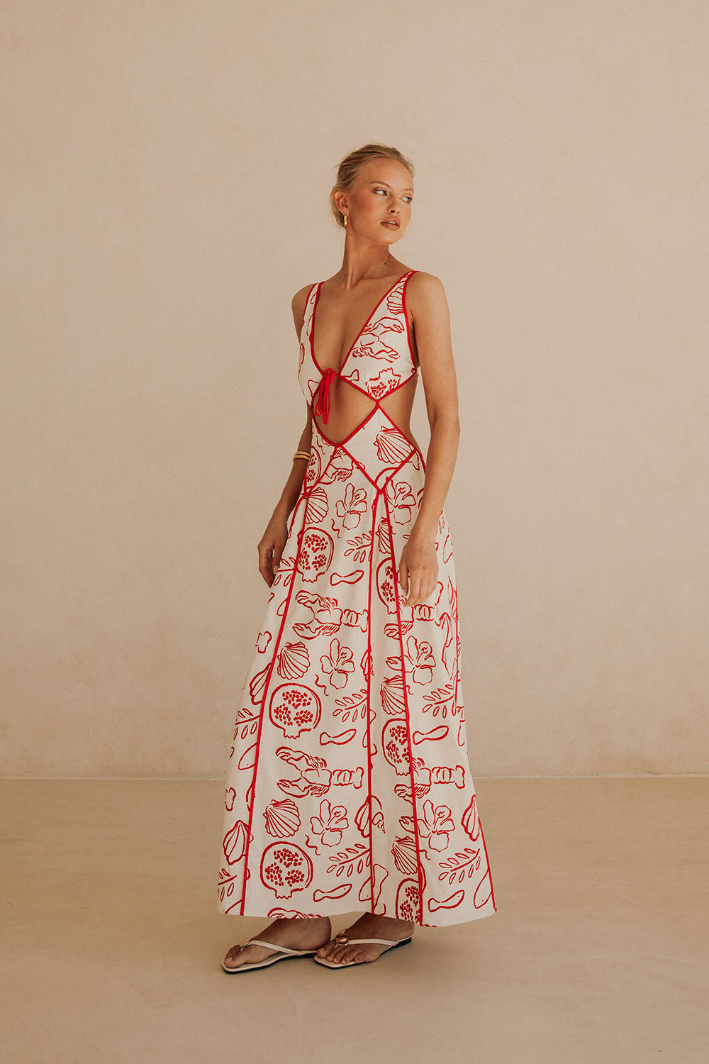 White Ophelia Maxi Dress with red marine print – cut-out waist, deep V-neck and flowy maxi length by Isadora London.