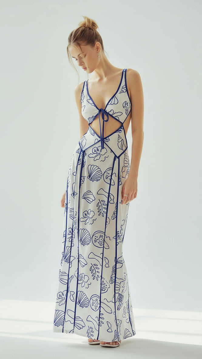 Model wearing the Ophelia Maxi Dress by Isadora London – white cut-out maxi with blue marine print, perfect for summer holidays and coastal getaways.