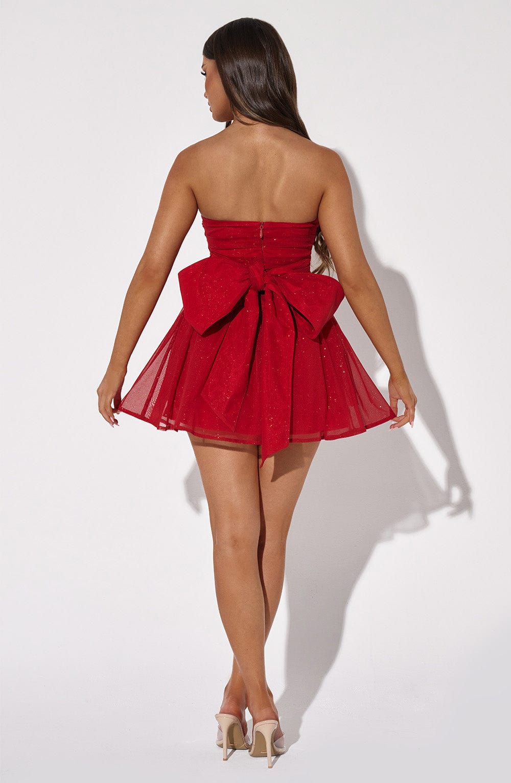 Back view of the Red Sparkle Mini Dress – oversized bow detail adds a feminine festive touch, perfect Christmas outfit from Isadora London.