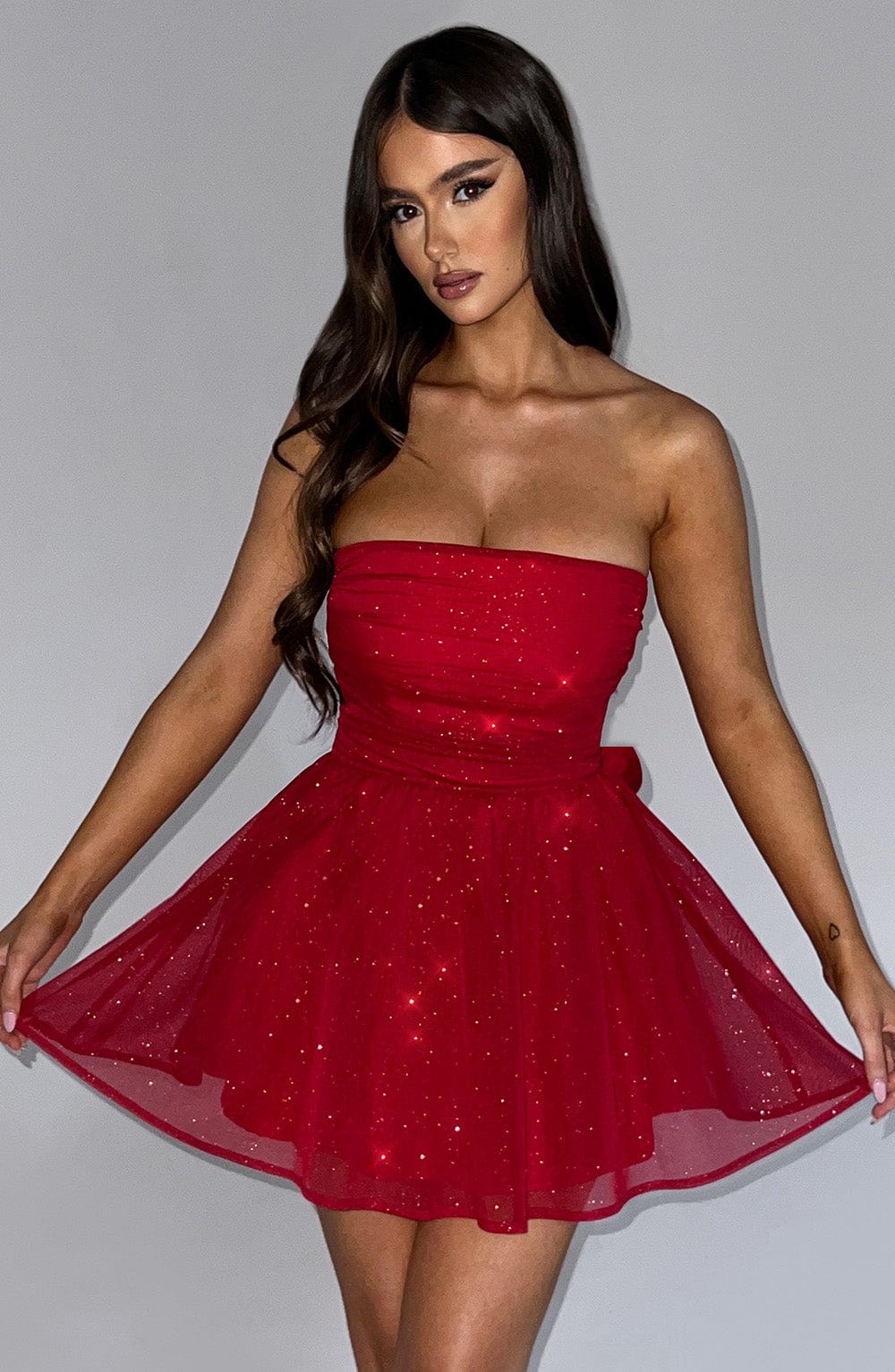 Side view of the Red Sparkle Mini Dress – elegant strapless design perfect for Christmas dinners and holiday nights, Isadora London.