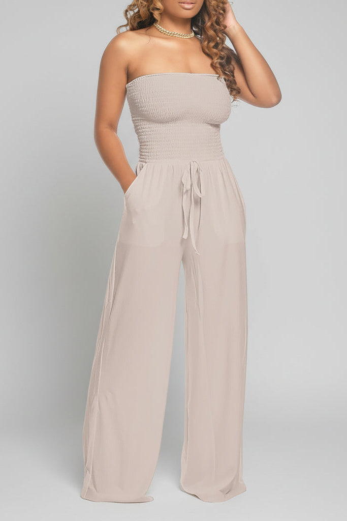 Model wearing a beige off shoulder jumpsuit with smocked bodice, wide-leg fit and tie-waist – casual and flattering style.